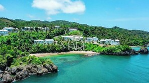 A coastal resort with multiple buildings, a beach, and clear turquoise waters. - Oceanfront paradise, sun-beach VII 302 (Samana)