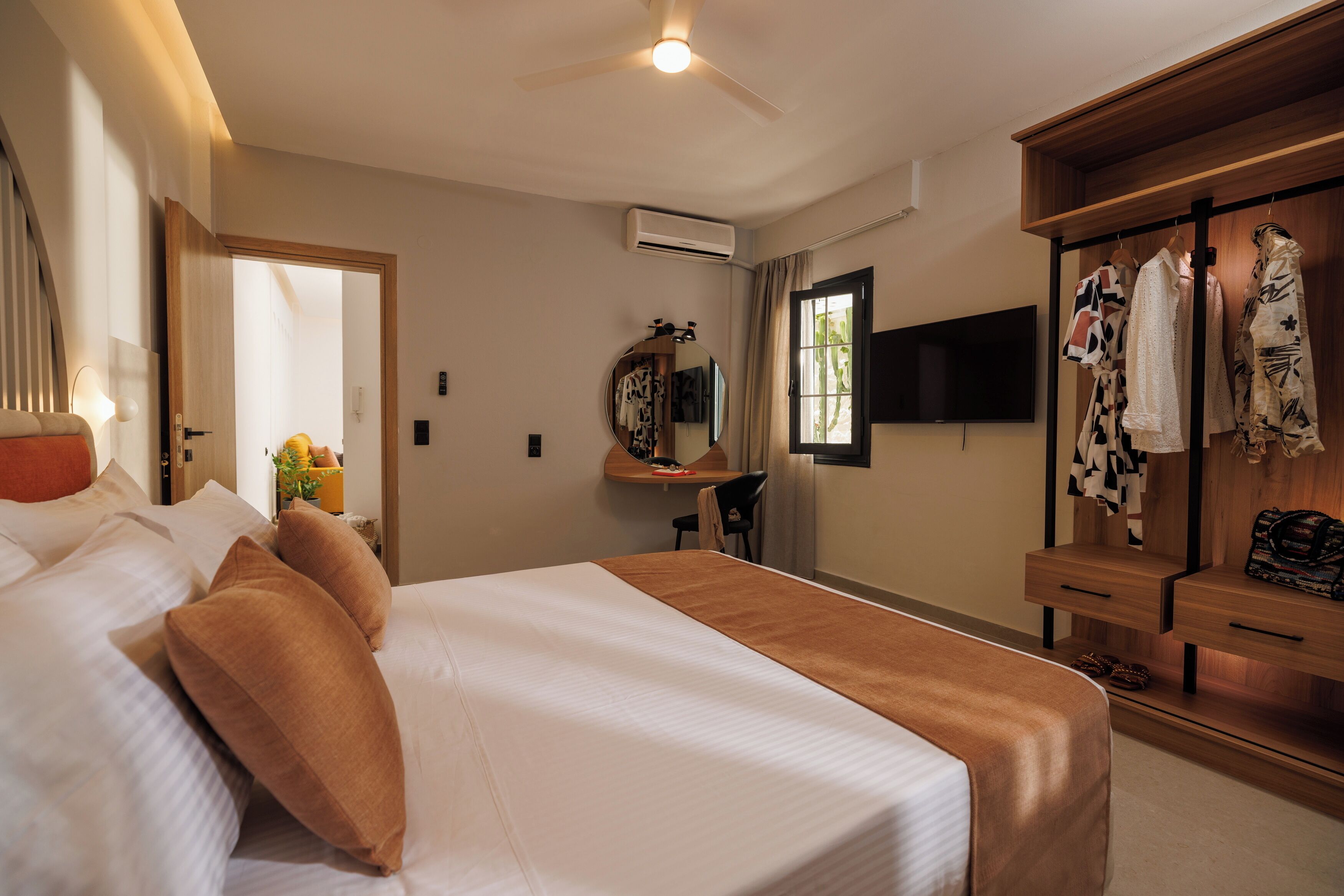 Een hotelkamer met een bed, een bureau, een spiegel, een kledingkast en een televisie.