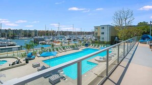 A marina with boats, a swimming pool with lounge chairs, and a building with a balcony. - The Mahogany' Full Boats View Marina Front Row Dream Pool, Jacuzzi And Gym (Marina del rey)