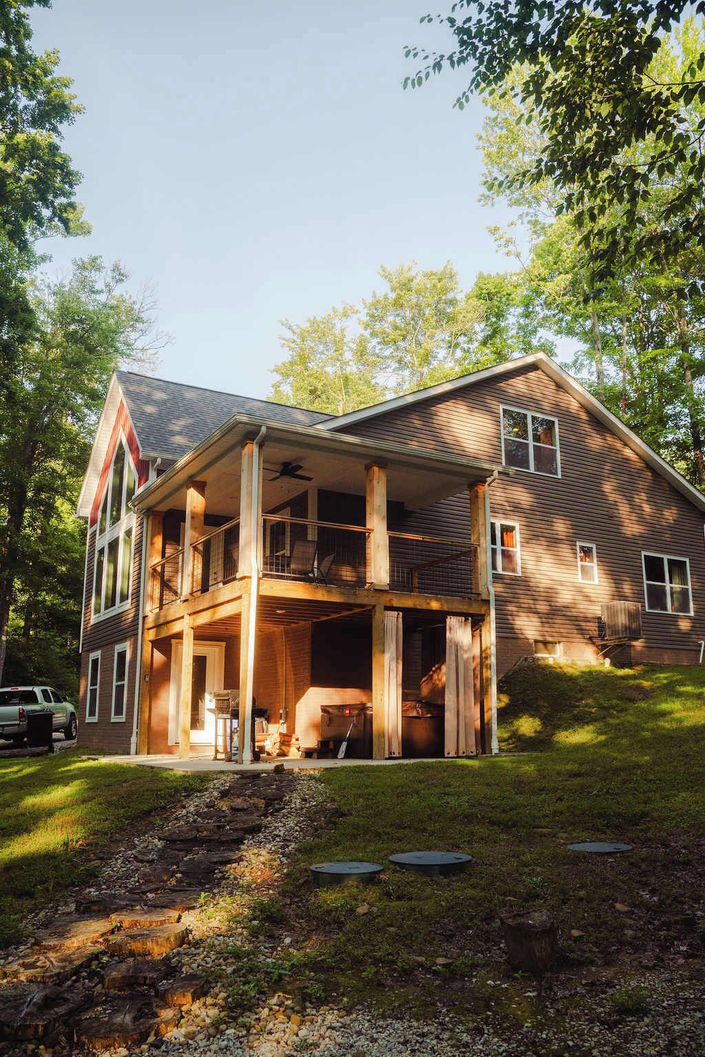 A two-story house with a covered porch and a large open garage area.