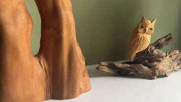 Una escultura de madera de un ave posada en una rama.
