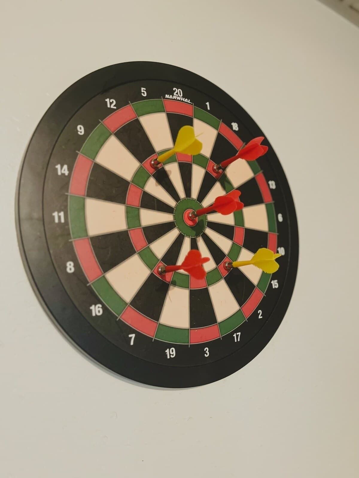 Un tablero de dardos con varias flechas clavadas.