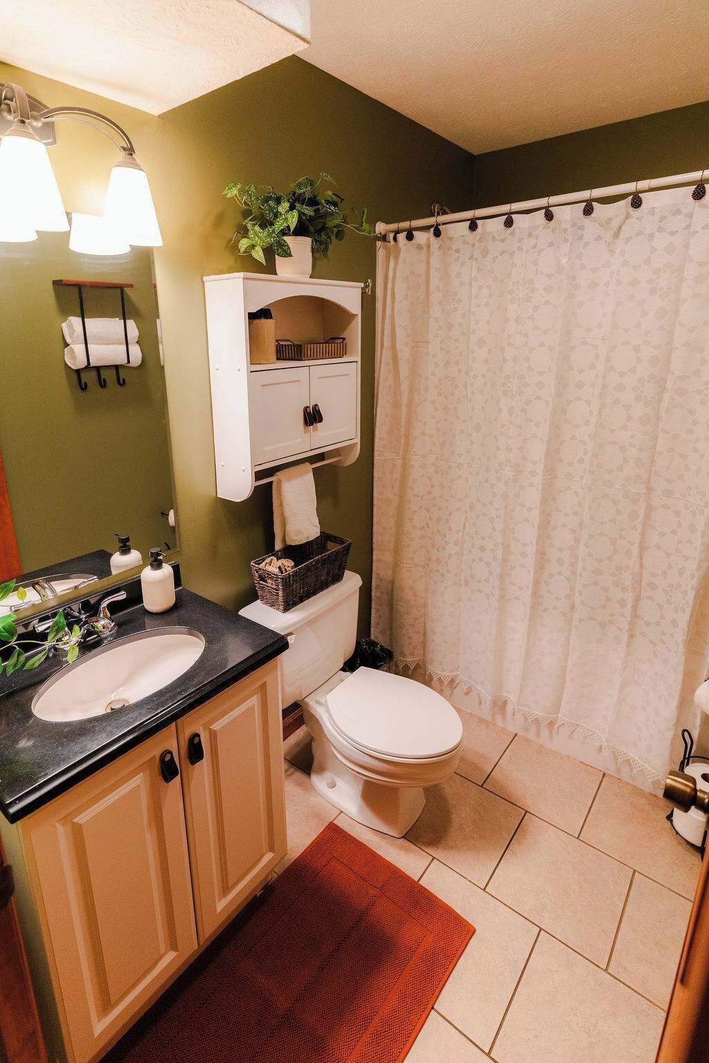 A bathroom with a sink, toilet, and shower curtain.