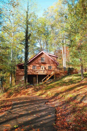 Eine Holzhütte mit Veranda und einer Treppe, die zum Eingang führt.