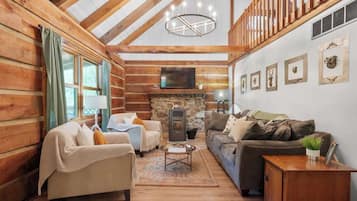 Huisje, Meerdere bedden, bubbelbad (Pine Ridge Cabin) | Woonruimte | Een open haard