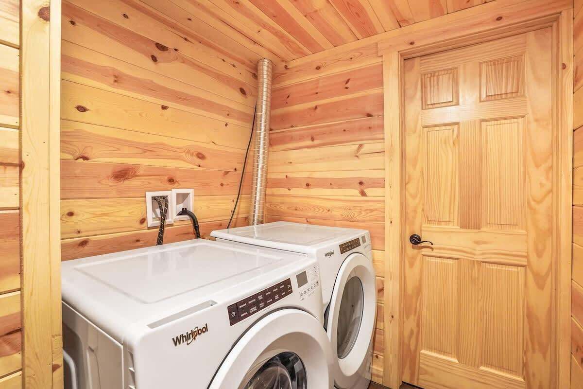 Ein kompakter Waschraum mit zwei Whirlpool Waschmaschinen und Trocknern, Holzwänden und einer Tür.