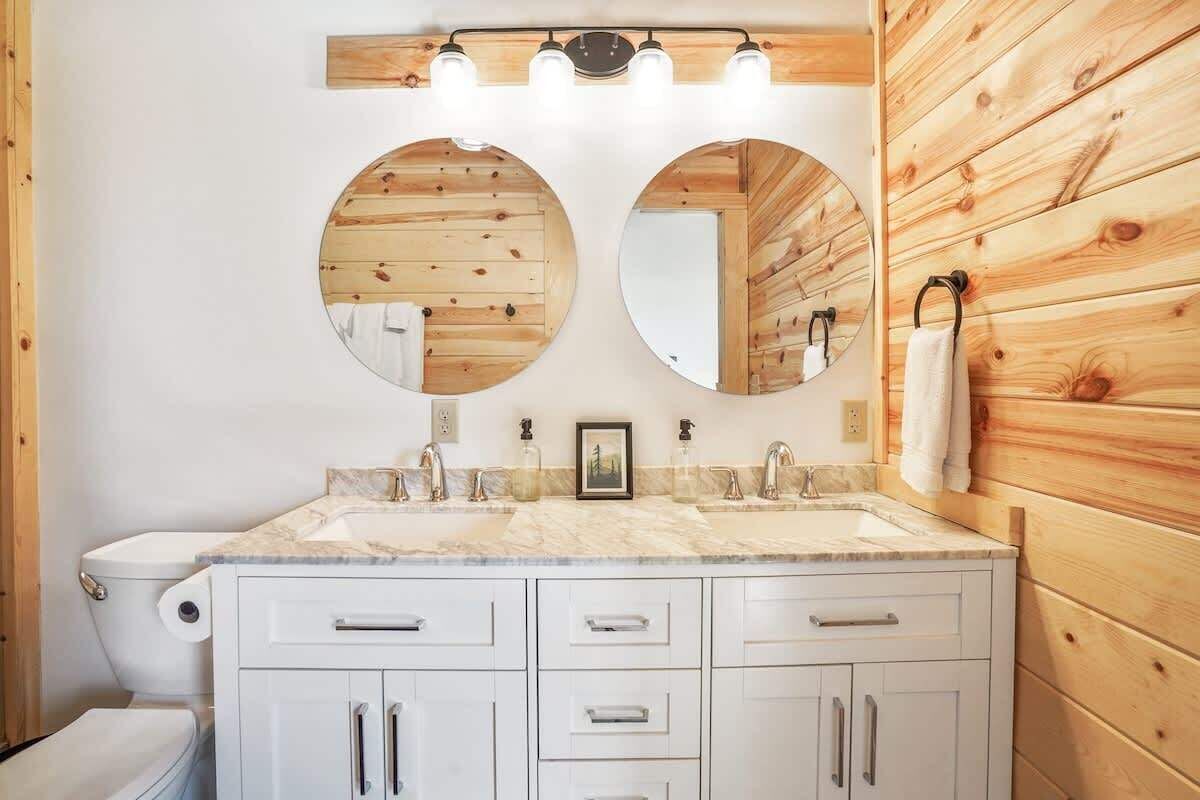 A bathroom with a wooden wall, a marble sink, and a toilet.