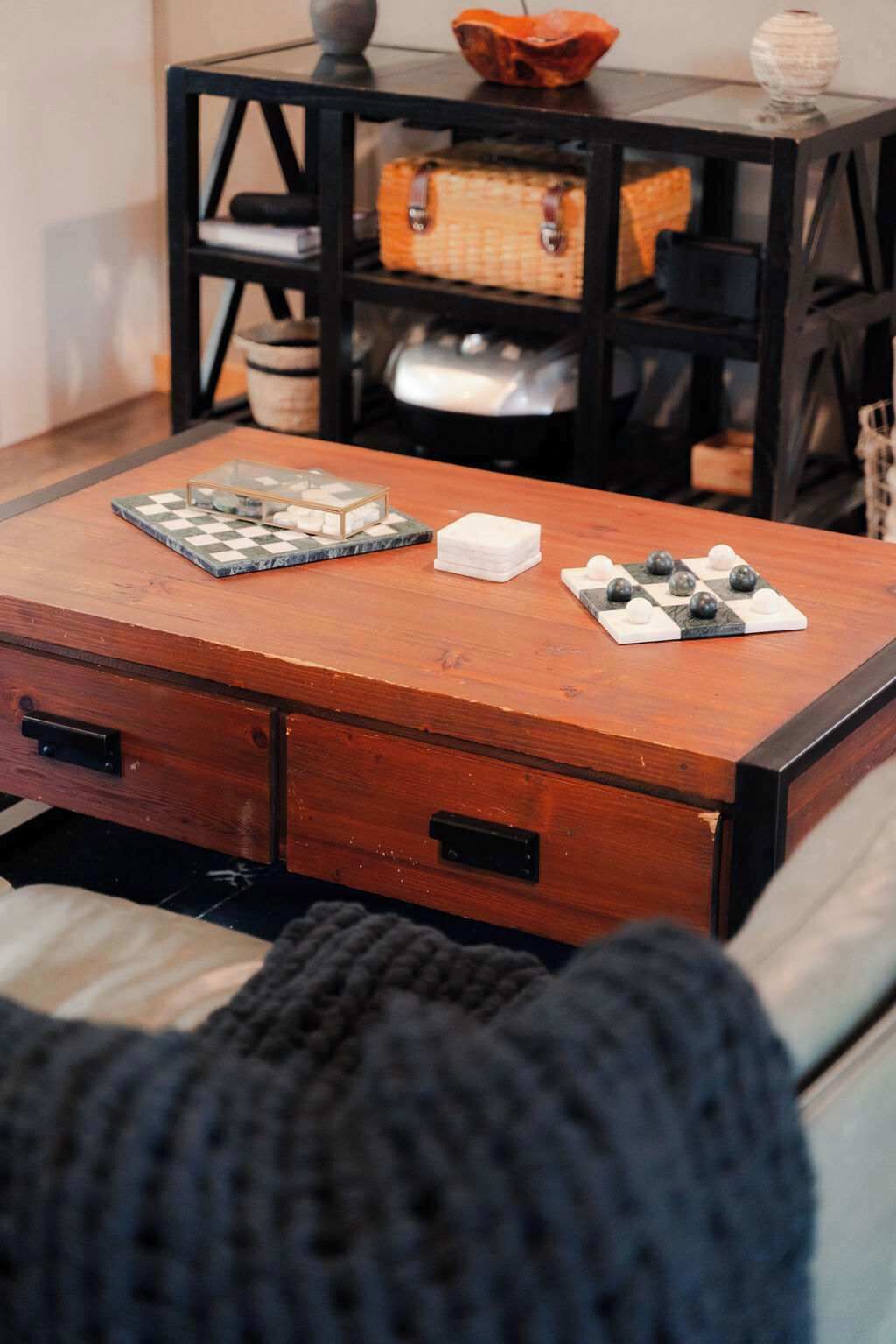 A wooden table with a chessboard and a small white box.