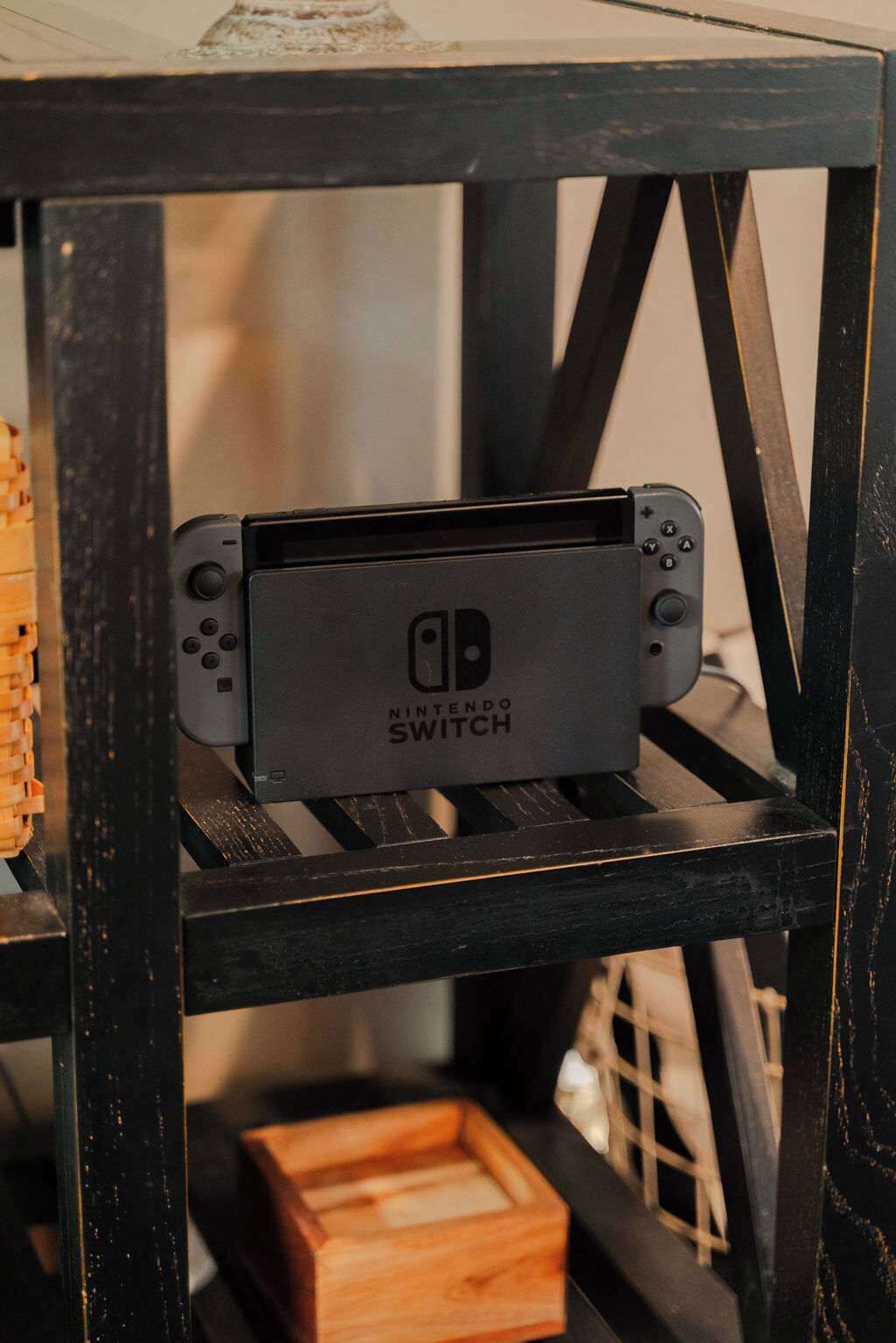 A Nintendo Switch on a black metal shelf.