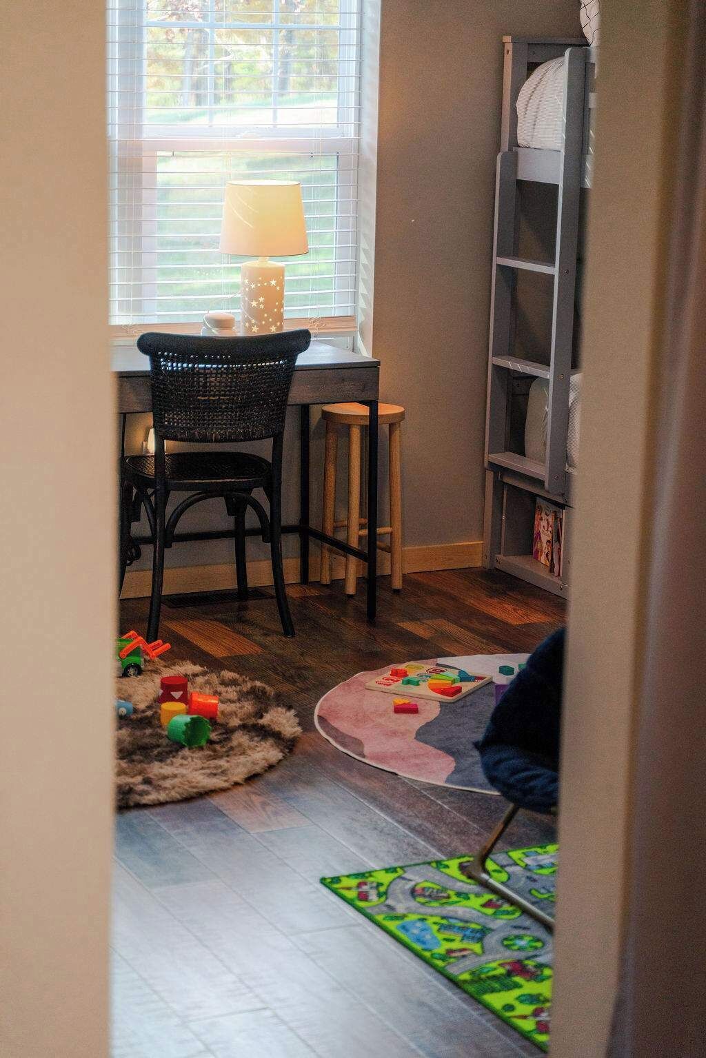 A child's play area with a desk, chair, and toys on the floor.