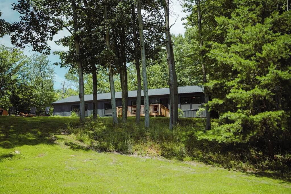 A building with a flat roof, surrounded by trees and grass.