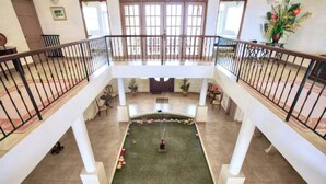 A spacious atrium with a central water feature, white columns, and a balcony railing. - Landsdown House - by Zenbreak (Oistins)