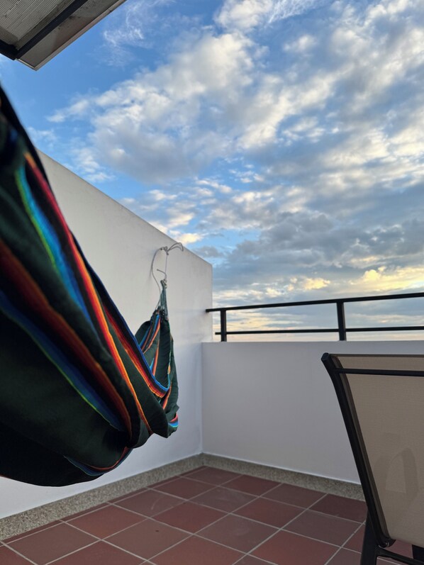 A balcony with a view of the sky and clouds.