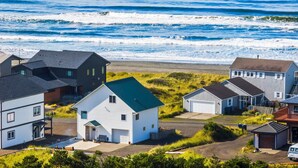 A coastal residential area with houses, a garage, and a sandy beach. - Beachfront ADA Cottage: Elevator, Sauna, fire pit (Westport)