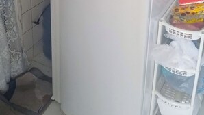 Una cocina compacta con un refrigerador blanco, un microondas y una licuadora en la encimera.