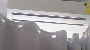 Un equipo de aire acondicionado instalado en el techo, con un panel de control visible y una etiqueta amarilla.