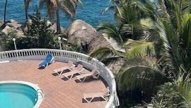 Un espace piscine avec des chaises longues et vue sur l’océan.