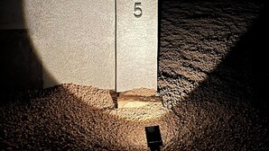 Un bâtiment doté d’une façade en béton et sur lequel on peut voir le numéro « 225 ».