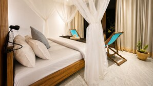 A bedroom with a bed, a chair, a massage table, and a potted plant. - cosybe villas Accmmodation (Tofo)