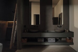 A modern bathroom with a dark wood vanity, two sinks, and a large mirror.