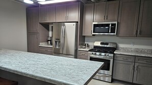 A modern kitchen with stainless steel appliances, marble countertops, and wooden cabinets. - Perfect 1-bedroom apartment in Marlette unit 2 (Marlette)