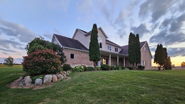 A large, two-story house with a well-maintained lawn and a variety of shrubs and trees. - Perfect 1-bedroom apartment in Marlette unit 2 (Marlette)