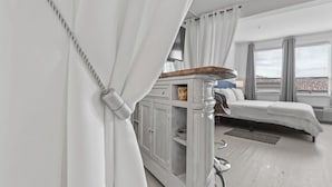 Une chambre d’hôtel moderne, équipée d’un lit, d’un bureau et offrant une vue sur la ville.
