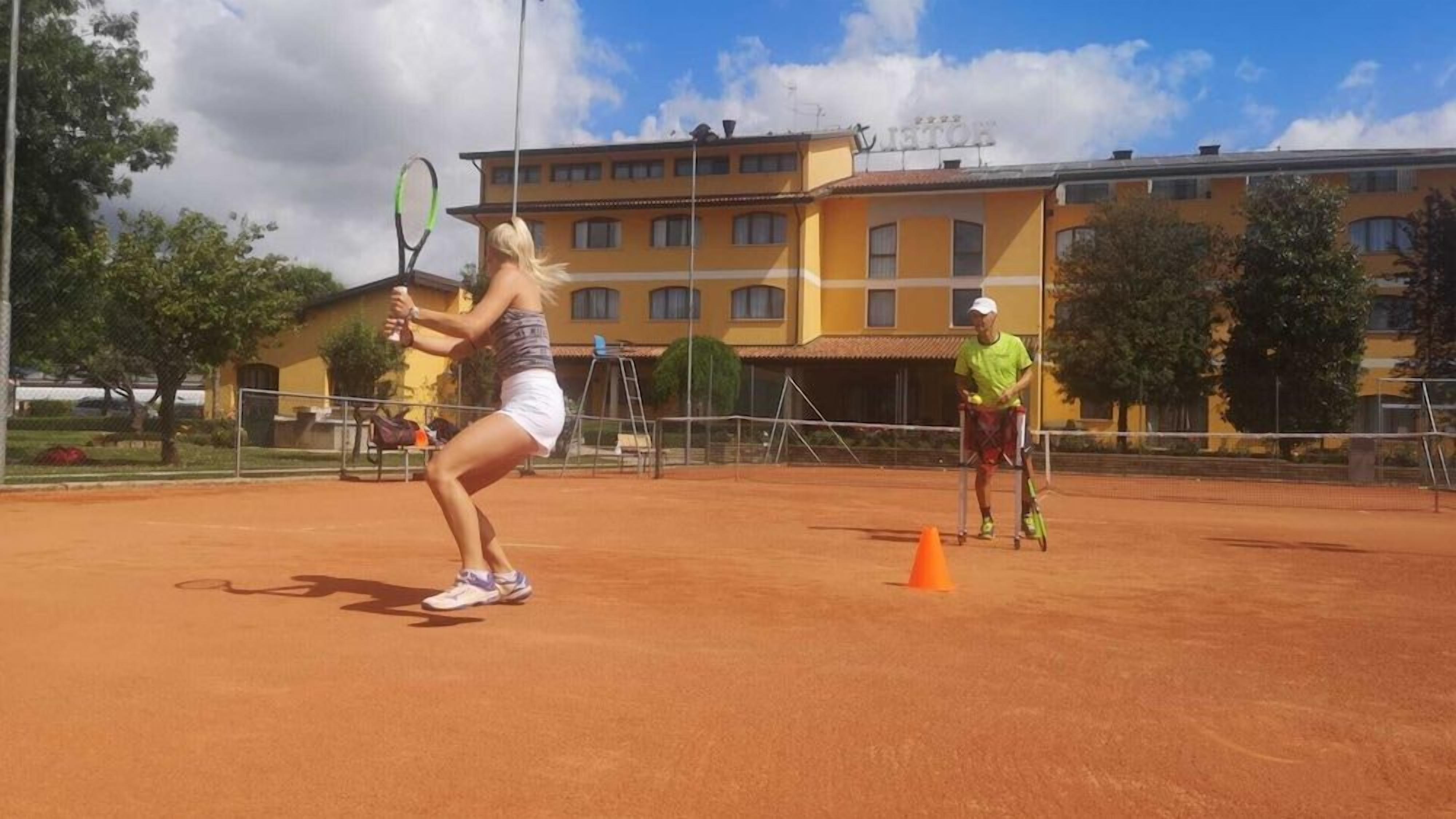 Ein Tennisplatz mit einem Gebäude im Hintergrund.