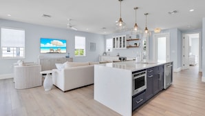 A modern kitchen with a central island, white cabinetry, and stainless steel appliances. - Luxury Waterfront Home - Marathon, FL Keys - 5BR, Private Pool, Dock - Sleeps 10 (Marathon)