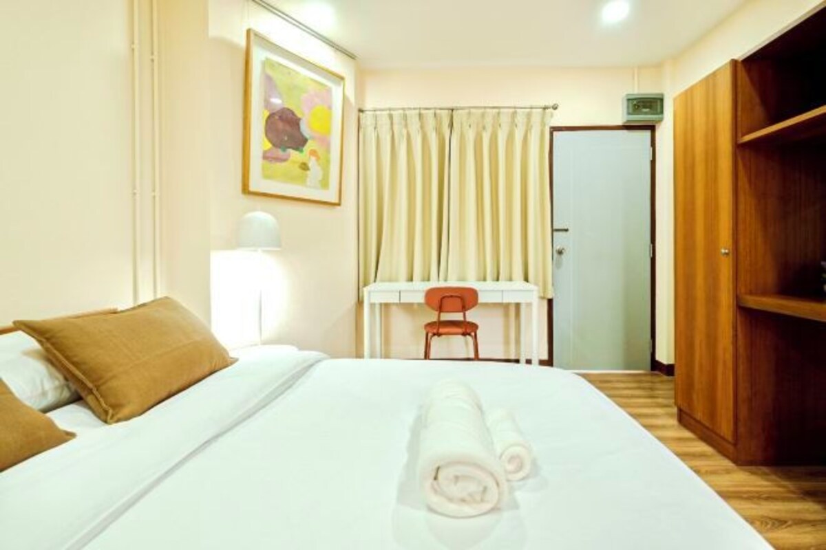 Une chambre d’hôtel comprenant un lit, un bureau, une chaise et une armoire.