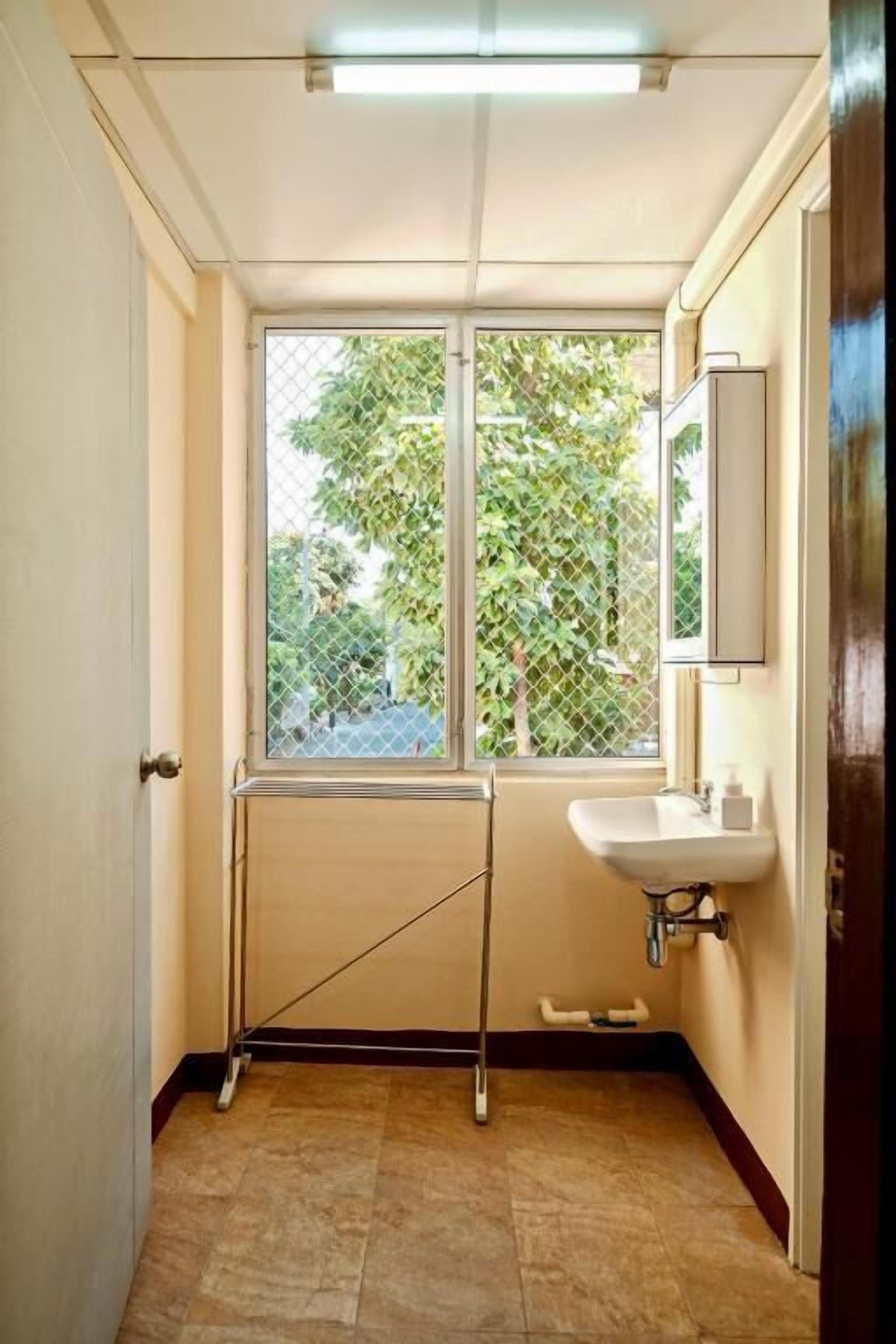 Une petite salle de bain avec une fenêtre, un lavabo et un miroir.