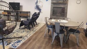 A modern dining area with a round table, chairs, a hanging chair, a fireplace, and artwork on the wall. - Quiet, Roomy,  Private Studio,  Beautiful view. (Independence)