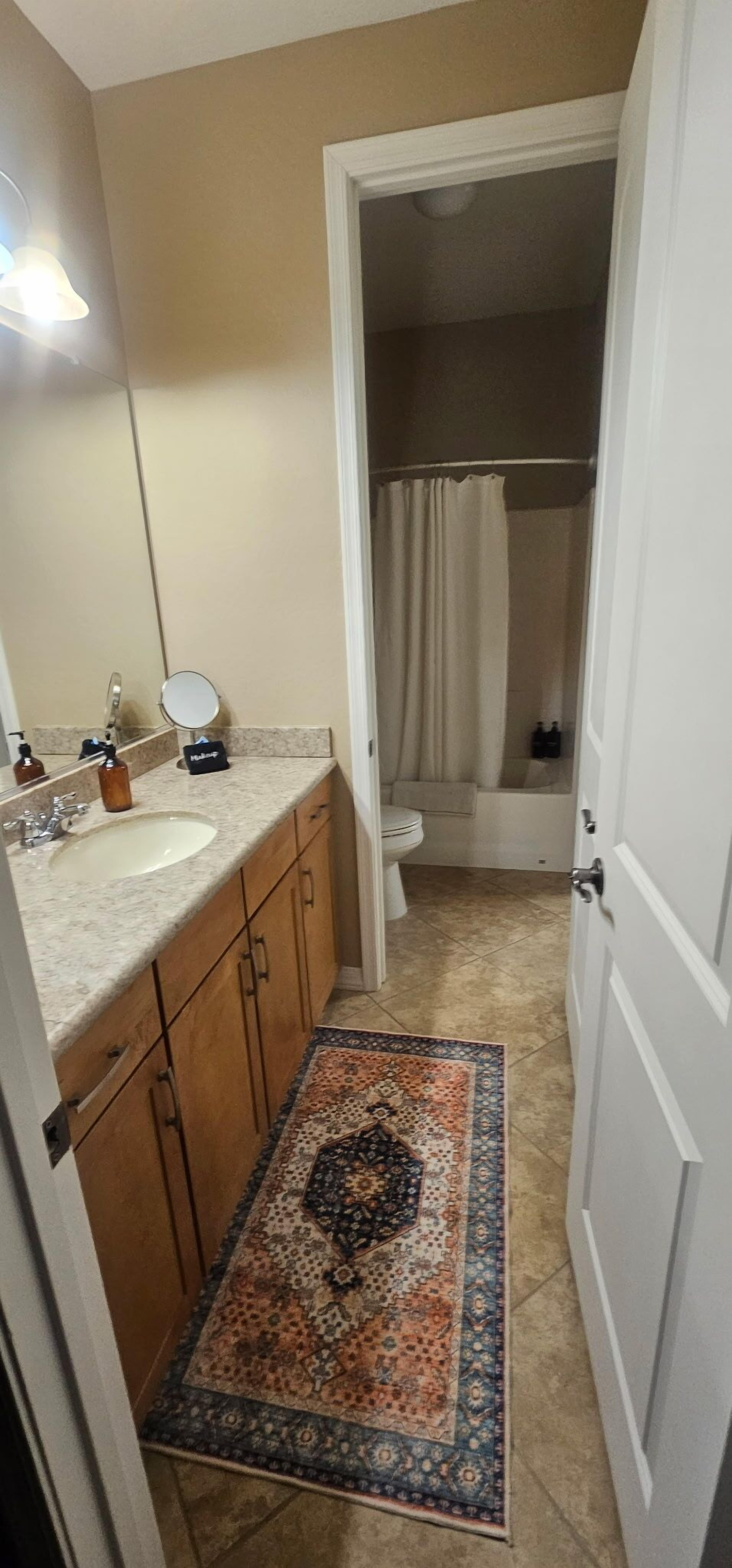 Une salle de bain avec un lavabo, un miroir et un rideau de douche.