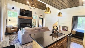 Una cocina moderna con una isla central, armarios de madera e iluminación colgante.