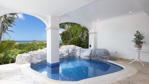 A hot tub with a view of the ocean, surrounded by rocks and plants. - One Old Trees | Beach Front - Located in  Beautiful Saint James with Private Pool (Saint James)