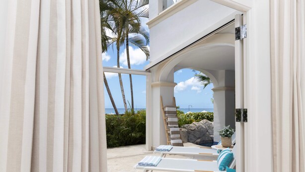 A beachside lounge area with white lounge chairs and a view of the ocean. - One Old Trees | Beach Front - Located in  Beautiful Saint James with Private Pool (Saint James)
