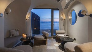 Una sala d'attesa moderna con sedute confortevoli, vista sul mare e un'ampia finestra ad arco.
