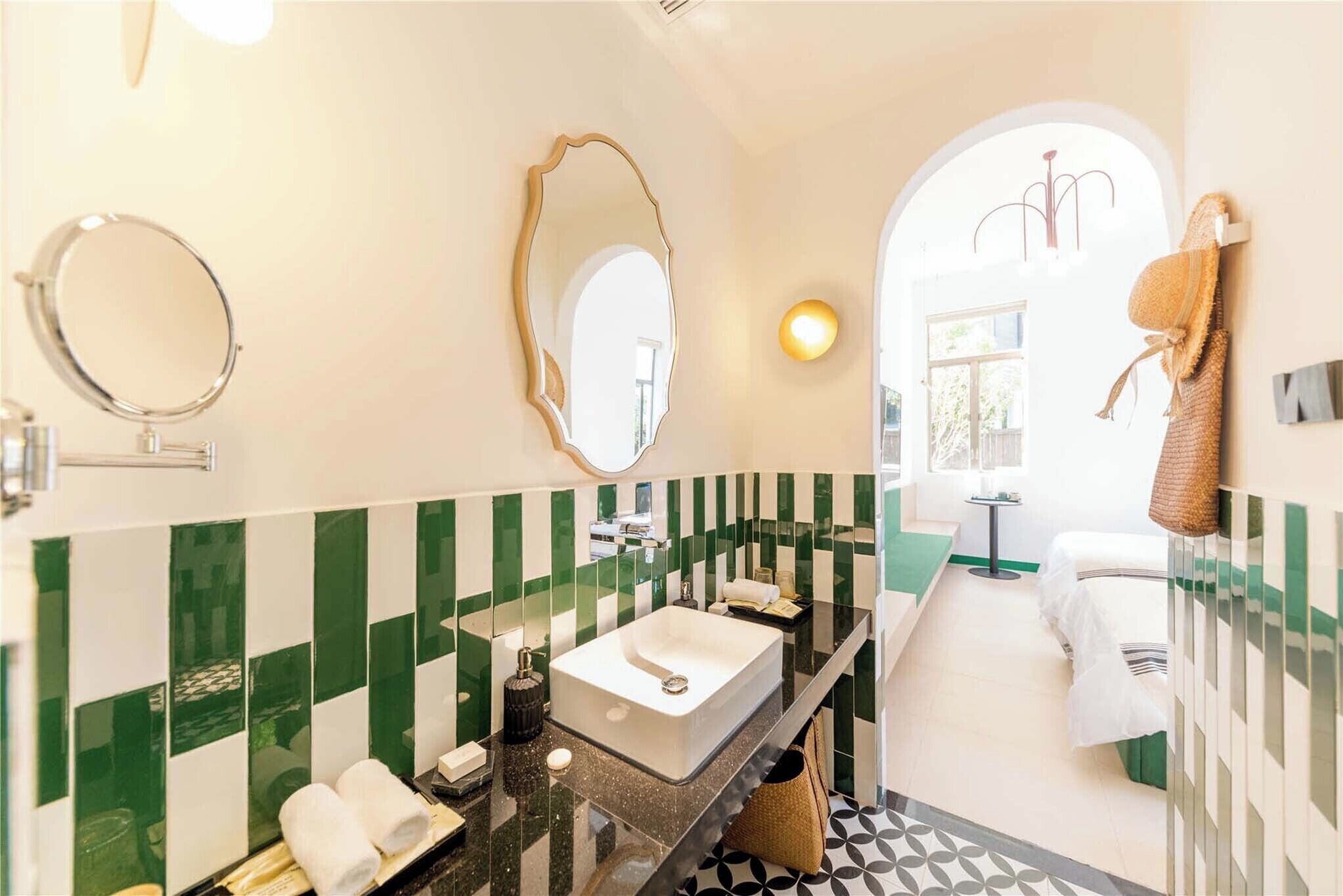 A modern bathroom with a large bathtub, two mirrors, and a vanity with a sink.