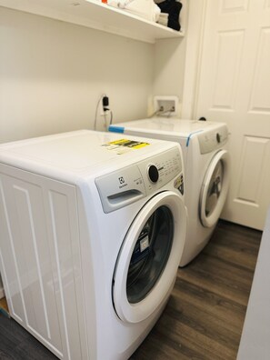 A laundry room with two white front-loading washing machines.