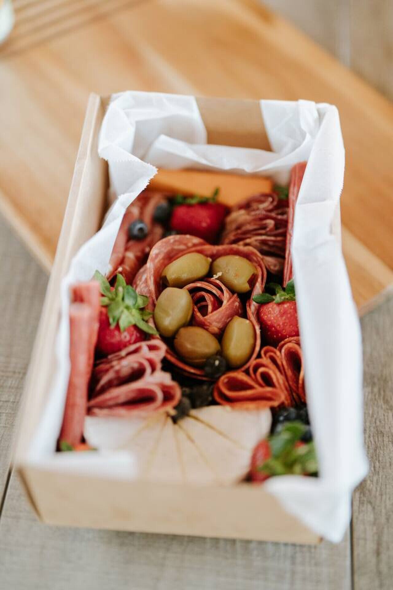 Tagliere con salumi misti, olive e fragole.