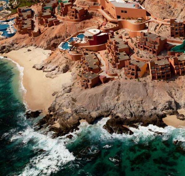 A coastal resort with multiple buildings, a beach, and a rocky shoreline. - Raintree's Club Regina Kitchenette Suite Jan17 to 24 (San José del Cabo)