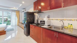 A modern kitchen with stainless steel appliances, wooden cabinets, and a large window with curtains. - Unwind Peaceful Near NaiHarn C200 (Rawai)