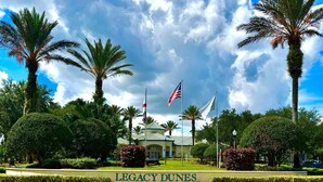 A well-maintained lawn with a sign reading "Legacy Dunes." - Wonderful apartment 10 minutes from Disney (Kissimmee)