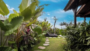 A garden pathway with stepping stones leading to a wooden structure.