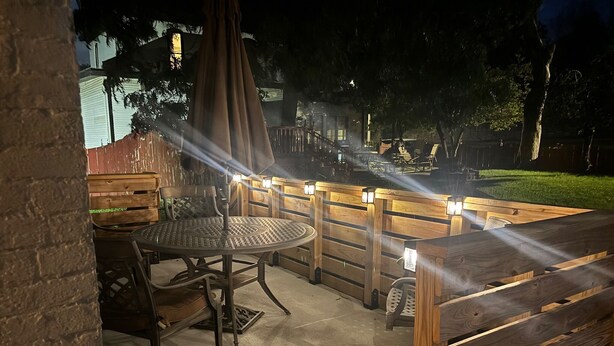 An outdoor patio area with a round table and chairs, wooden benches, and a pergola providing shade. - Historic Alton duplex! Upper unit (Alton)