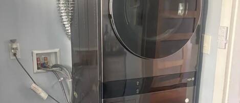 Un lavadero moderno y funcional con dos lavadoras negras grandes, una manguera y un calentador de agua.