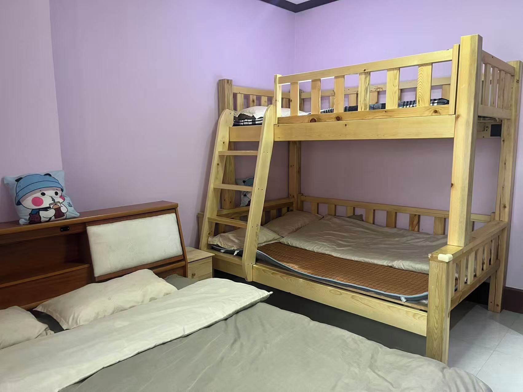 A bunk bed with a ladder, a bedside table, and a chair.