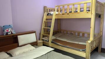 A bunk bed with a ladder, a bedside table, and a chair.