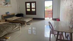 Une chambre avec deux lits, une table et une chaise. Il y a une fenêtre donnant sur l’extérieur.