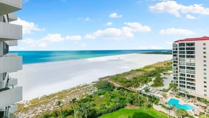 Een strandhotel met een zwembad, een strand en een helder uitzicht op de oceaan.